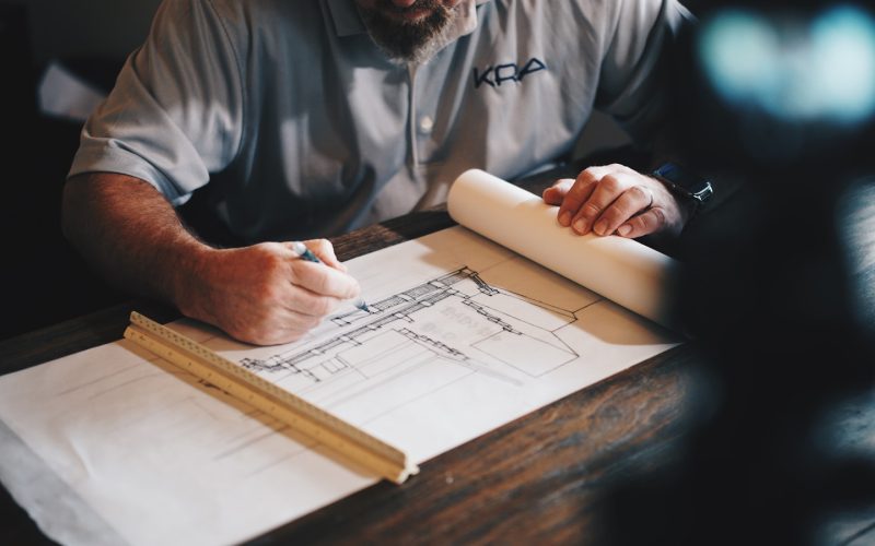 An architect working on a draft with a pencil and ruler