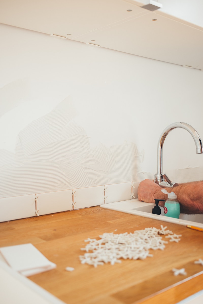 person holding gray curved faucet